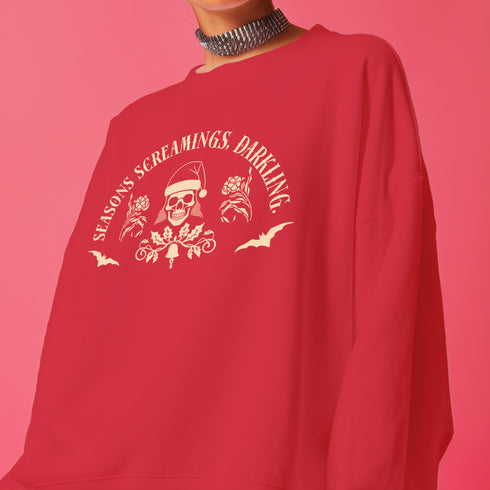 Christmas sweatshirt with "SEASONS SCREAMINGS, DARKLING" text arched over a skull wearing Santa hat. Bats, flowers, and ornate designs surround the skull in vintage-inspired style.
